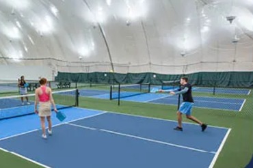 Three pickleball players on a pickleball court